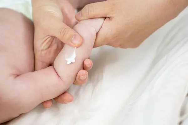 Nakładanie kremu na ciało dziecka w okolicy zgięcia łokci